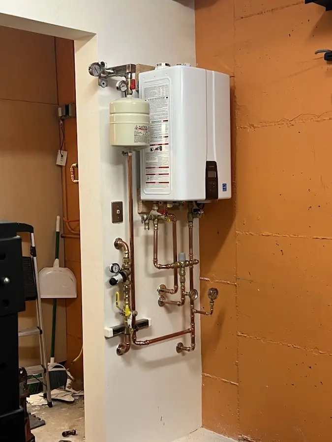 Plumbing technician inspecting water heater connections in Rockland